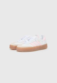 Hvide sneakers med lyserøde accenter, ruskinds tåbælg og tre lyserøde striber på siden. Tekstureret gummisål.
