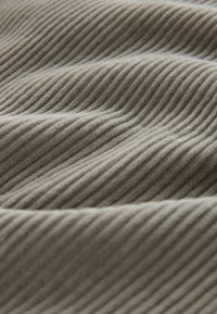Strukturierter Stoff in gedämpftem Grau-Braun mit subtilen vertikalen Ripp-Linien. Weiche und leicht flauschige Oberfläche mit wellenförmigem Muster.