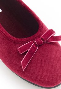 Ballerina bordeaux realizzata in morbido velluto, con punta arrotondata e un piccolo fiocco in velluto coordinato sul davanti.