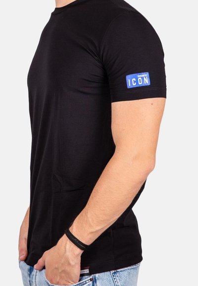 T-shirt nera a maniche corte, con un'etichetta blu "ICON" sulla manica sinistra. Realizzata in tessuto morbido, aderisce bene al torso.