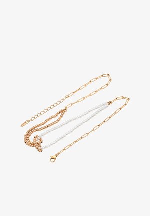 Guldtonet, flerlagers halskæde med en blanding af runde perler, perlestrenge og aflange kædelinks med en smælderlås.