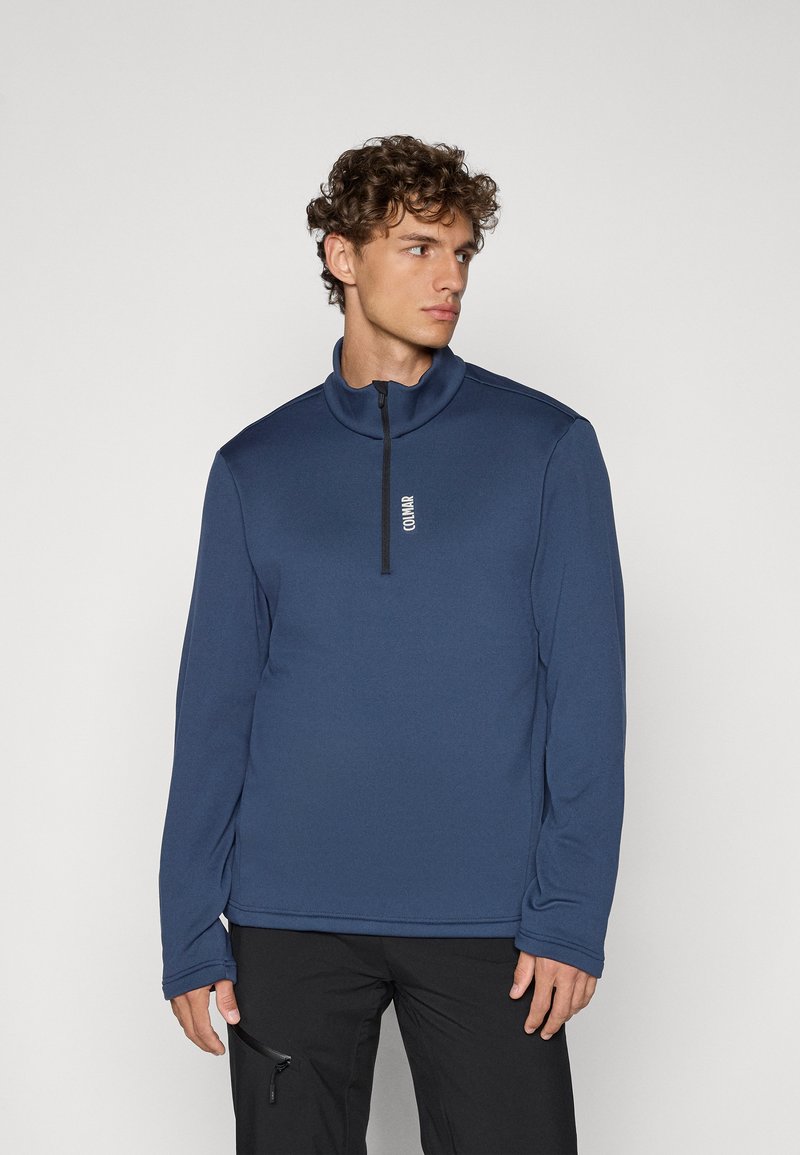Sudadera de forro polar azul marino con un alto cuello y una cremallera de un cuarto de longitud. Cuenta con un sutil logo en blanco en el pecho y mangas largas.