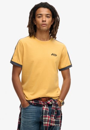 Yellow cotton t-shirt with short sleeves, gray accents on the cuffs and shoulders, embroidered logo on the chest. Casual fit, plain design.