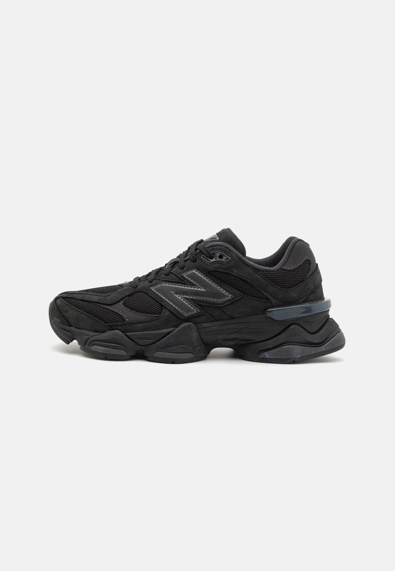 Black athletic shoe featuring a mesh and suede upper, prominent cushioning sole, textured accents, and reflective logo detail.