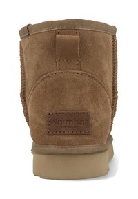 Bruine suède enkelboot met een ronde vorm, versterkte hak en gestikte accenten. Bevat een logo-opdruk op de achterkant en een platte zool.