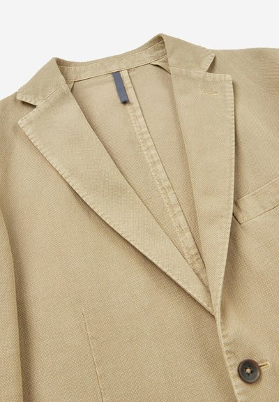 Beige blazer van gestructureerde stof, met een notch lapel, enkele knoopsluiting en een borstzak.