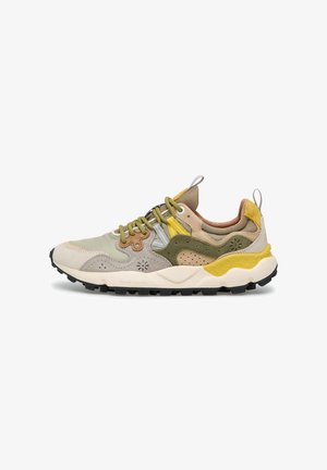 Scarpa da ginnastica multicolore con suede beige, oliva, giallo e tabacco e mesh, lacci gialli e suola bianca e nera texturizzata.