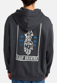 Gray hoodie with a loose fit featuring a large white and blue graphic of a hand with vines and text "KEEP GROWING" on the back.