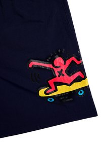 Navy shorts featuring a printed design of a red figure skateboarding on a yellow board with black and blue accents. Smooth texture.