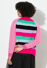 Multikleurige gebreide trui met een hoge kraag. Heeft gedurfde strepen in roze, groen, zwart en lavendel, met textuurrijke roze geblokte mouwen.