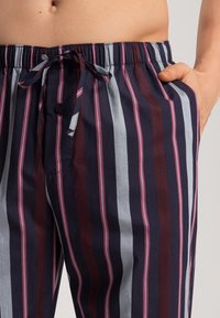 Gestreepte katoenen pyjamabroek met een trekkoord in de taille. Met verticale navy, wijnrood, grijs en roze strepen. Inclusief zijzakken.