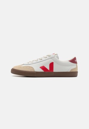 Vita lädersneakers i vitt med röd V-logotyp, beige mocka på framtån och brun gummisula. Har en klassisk snörning och vadderad krage.