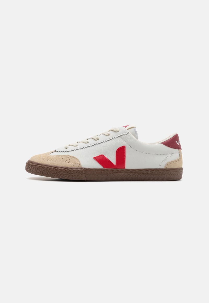 Zapatilla blanca de cuero con logo V rojo, capucha de ante beige y suela de goma marrón. Cuenta con un diseño clásico de cordones y un collar acolchado.