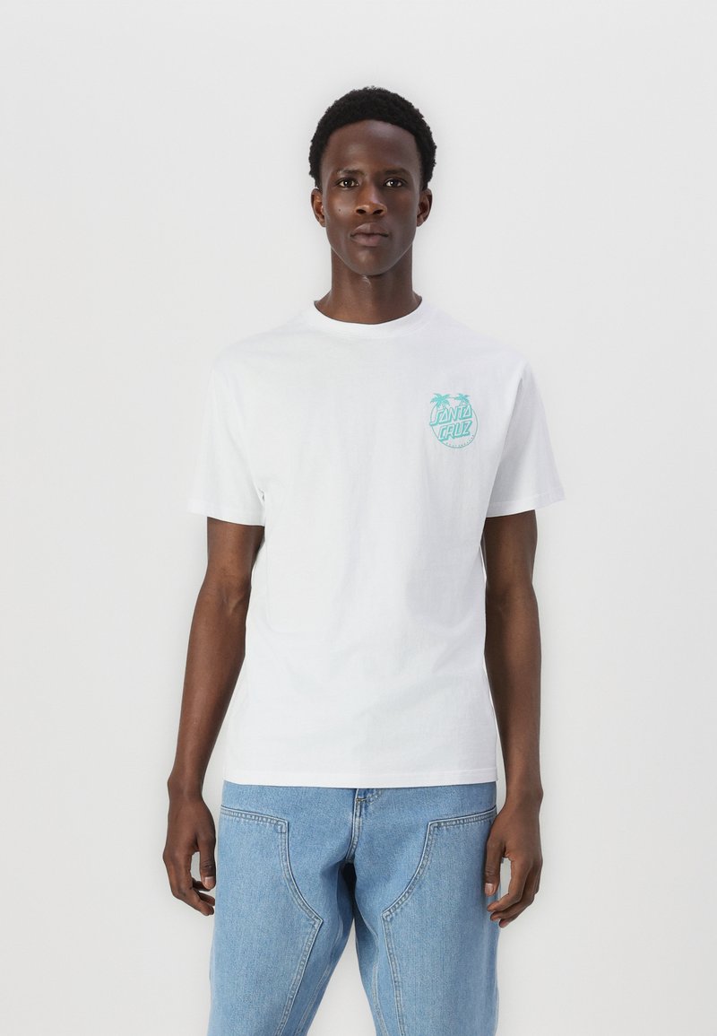 White cotton t-shirt featuring a light blue graphic design of palm trees and text on the left chest. Paired with light blue denim jeans.
