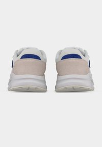 Αθλητικά παπούτσια Lacoste με λευκό πλέγμα στο πάνω μέρος, μπεζ σουέντ λεπτομέρειες, μπλε λογότυπο και υφασμένη λαστιχένια σόλα.