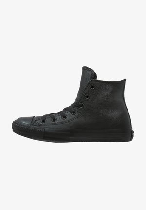 Adidași înalți negri, din piele texturată, cu vârf din cauciuc și șase găuri pentru șireturi. Prezintă un guler pentru gleznă fără cusături.