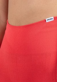 Ribattu koroho pöksy með háum mitti, með litlu "SMILODOX" merkinu á mitti. Stretchy efnið eykur þægindi og fit.