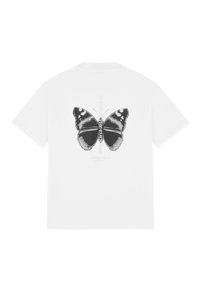 Camiseta blanca de algodón con un estampado gráfico de un diseño de mariposa simétrica en negro y gris en la parte posterior, con texto debajo.