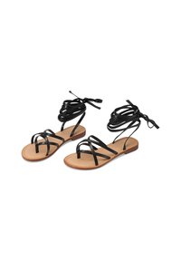 Sandali in pelle nera con molte sottili cinghie e una suola piatta color marrone chiaro. Presentano lunghe stringhe che si avvolgono attorno alla caviglia per una vestibilità sicura.