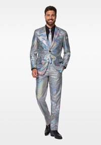 Silberner Anzug mit einem Gittermuster, das verschiedene Farben reflektiert. Maßgeschneidertes Design, einreihiger Blazer, schwarze Krawatte und polierte schwarze Schuhe.