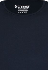 Marineblauwe getailleerde T-shirt, gemaakt van 90% biologisch katoen en 5% elastaan, met een ronde halslijn en een soepele textuur. Merkenlabel op de nek.