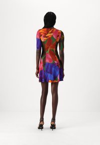 Robe à manches courtes avec un motif floral dans des couleurs vives comprenant du rose, du violet et de l'orange. Design ajusté et évasé avec une longueur mi-cuisse.