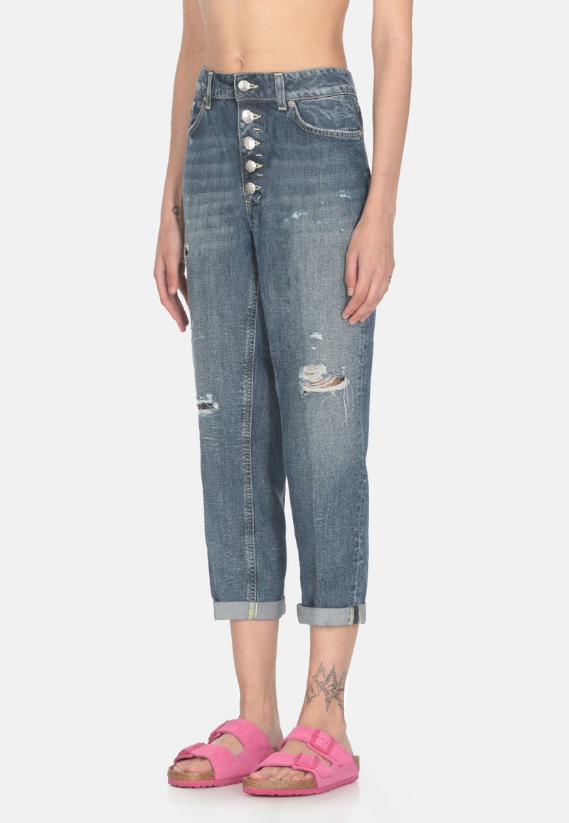 Jeans in denim con dettagli strappati, vita alta, chiusura a cinque bottoni, gamba affusolata e orlo arrotolato. Abbinati a sandali in suede rosa.