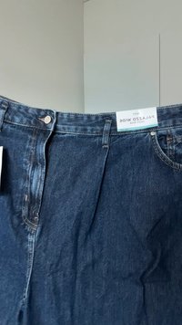 Dunkelblaue Palazzo-Jeans in weitem Schnitt mit hohem Bund, vorne mit Reißverschluss und Knopfverschluss, vor hellem Hintergrund präsentiert.