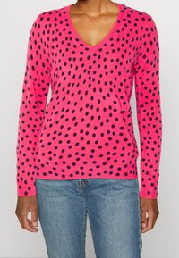 Maglione fucsia a V con pois blu navy, maniche lunghe e polsini e orlo a coste, realizzato in morbido materiale a maglia.