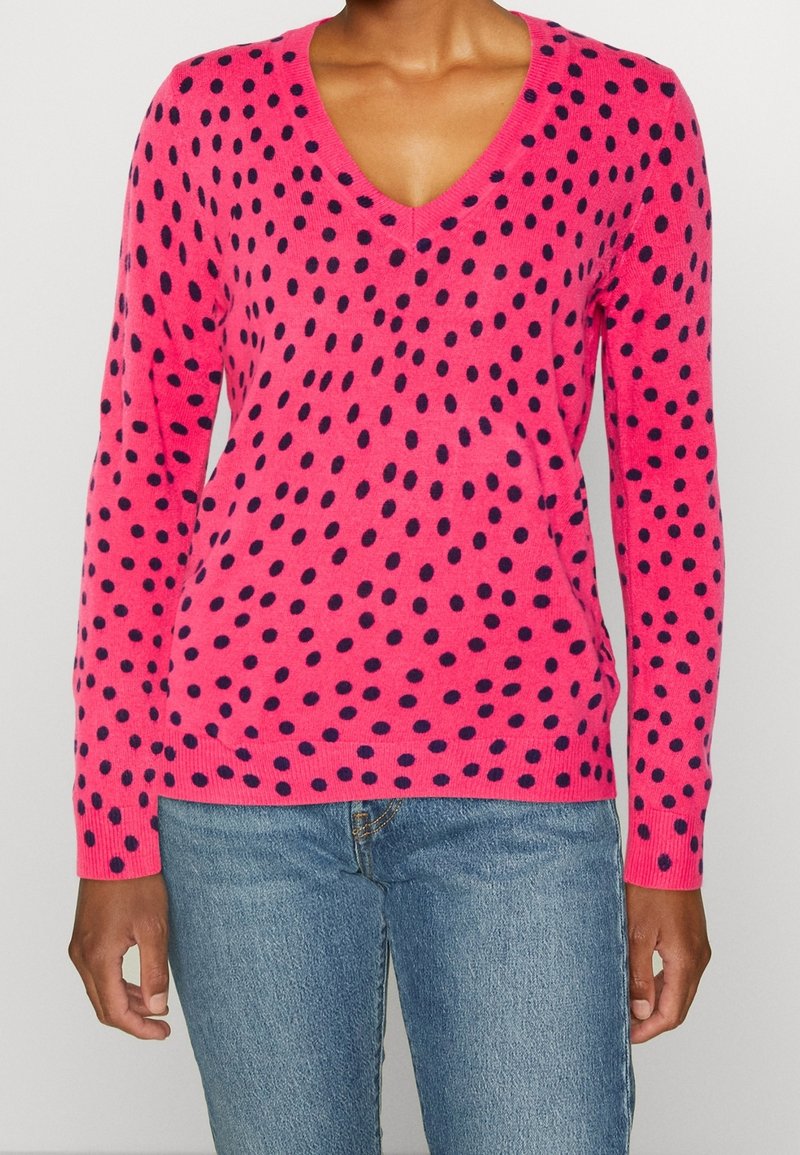 Maglione fucsia a V con pois blu navy, maniche lunghe e polsini e orlo a coste, realizzato in morbido materiale a maglia.