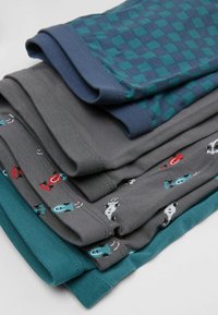 Pila de pantalones cortos de algodón en varios colores: turquesa, gris con estampados de animales y un diseño de cuadros en azul y verde. Tela suave con cinturillas elásticas.