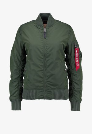 Õlivääris roheke pusa, millel on ribakrae ja -manšetid, ees tõmblukk, küljetaskud ning punane silt, millel on kirjas "EEMALDADA ENNE LENNU KÄIMA LÄHET".