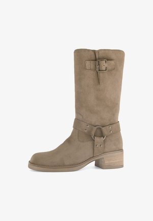 Brown suede knee-high boot with a rounded toe, a side buckle accent, and a stacked wooden heel. Smooth texture and minimalist design.