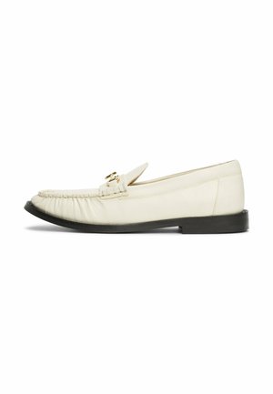 Cream leather loafers with a rounded toe, featuring a decorative gold-tone buckle and gathering detail at the front, set on a black sole.