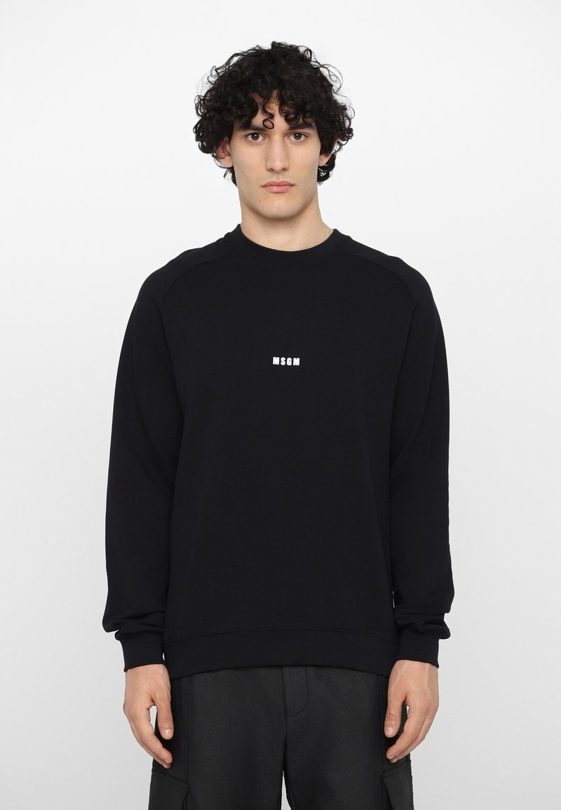 Sweatshirt noir à manches longues et ourlet côtelé, arborant le logo blanc "MSGM" sur la poitrine. Fabriqué en doux mélange de coton.