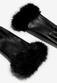 Čierne kožené rukavice s mäkkým čiernym umelým kožuchom na zápästí. Elegantný dizajn s hladkou textúrou, s tromi otvormi na prsty.