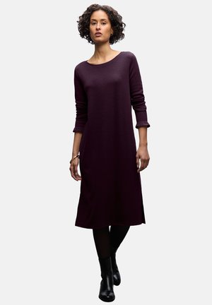 Pitkähihaisessa, violetissa mekossa on pyöreä pääntie. Pehmeä kangas, rento malli, sivuhalkiot helmassa, yhdistetty mustiin nilkkabootseihin.