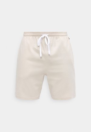 Shorts décontractés beige avec taille élastique et cordon blanc, en tissu doux, présentés sur un fond uni.