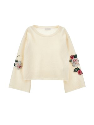Kremfarget genser med rund hals og klokkelignende ermer, prydet med blomsterbroderi i rosa og rødt på ermene. Myk tekstur.