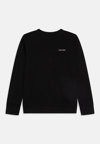 Svart hettegenser laget av myk stoff, med rund halslinning og ribbede mansjetter. Fronten har en liten hvit "Calvin Klein" logo.