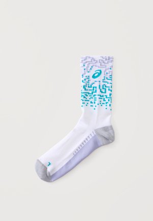 Chaussette de sport blanche avec talon et pointe gris, semelle violette, motif pixélisé violet et bleu sarcelle avec logo sur le bord supérieur.
