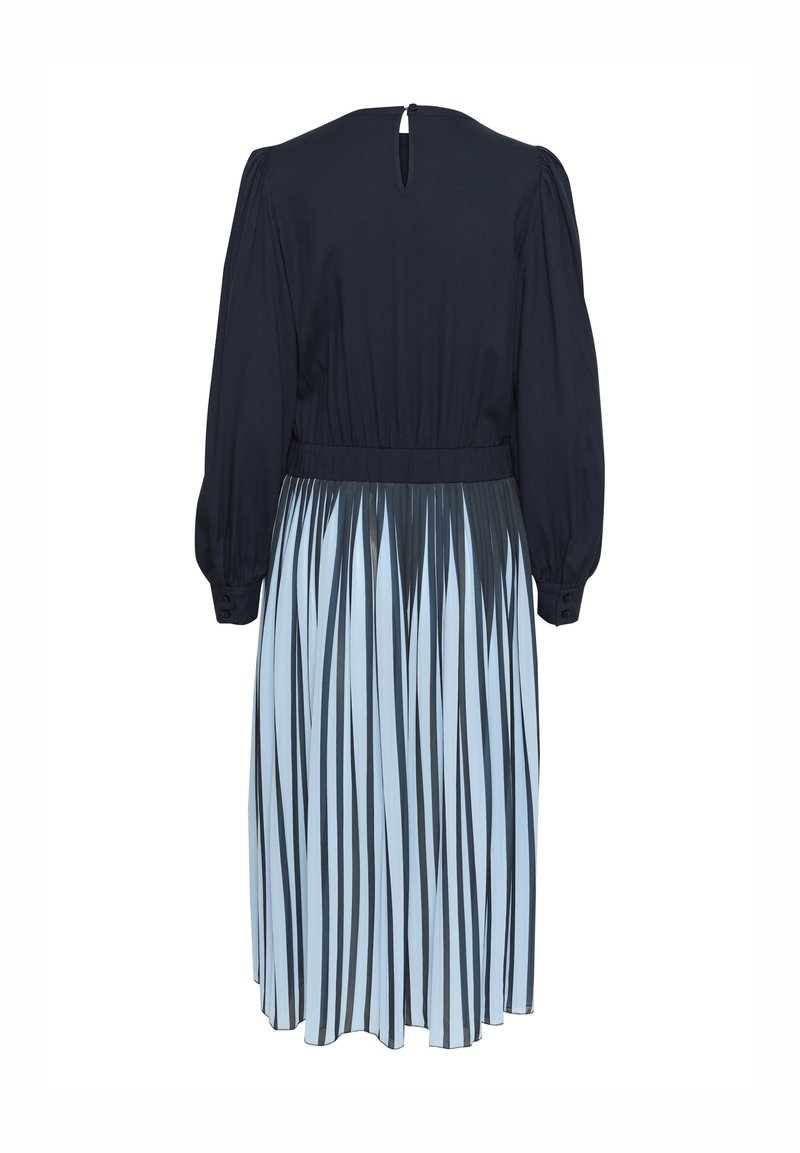 Tume sinine ülemine osa, millel on pikad puhvärvid ja talje, ning mis üleminekul sulandub helesinisesse seeliku, millel on tumedad vertikaalsed triibud ja pealset läbipaistvus.