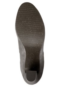 Podeszwa szarego zamszowego buta z teksturowanym gumowym spodem i prostokątnym elementem na obcasie, z nazwą marki "Scholl" na części śródstopia.