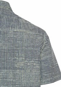 Korte mouwen shirt met een bedrukte stof, voorzien van kleine blauwe en witte vierkanten. De kraag is plat en heeft een gladde textuur.