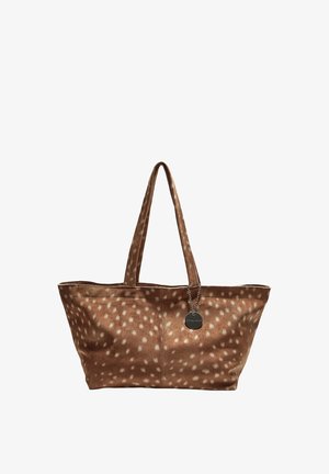 Braune Tragetasche aus weichem Stoff, mit einem gepunkteten Muster in helleren Farbtönen, stabilen Griffen und einem an einer Metallkette befestigten Anhänger.