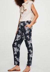 Námořnické kalhoty s bílým tropickým potiskem, lehký materiál, volný střih, elastický pas, boční kapsy, spárované s béžovým pleteným topem.