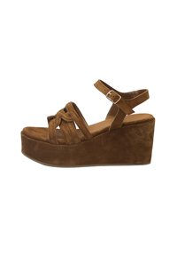 Braune Wildleder-Plateau-Sandalen mit einem massiven Keilabsatz, ausgestattet mit überkreuzten Riemen und einem verstellbaren Knöchelriemen. Glatte Textur und einfarbig.