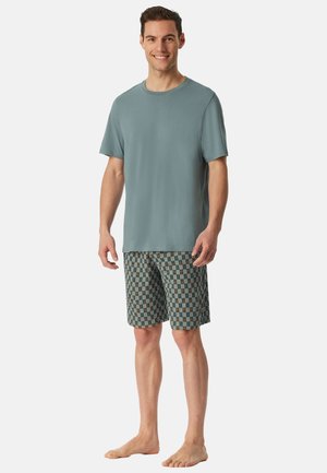 Herenoutfit bestaande uit een teal ronde hals t-shirt en geruite shorts in blauwe, groene en bruine tinten met een ontspannen pasvorm.