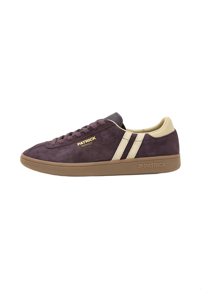 Zapatillas de ante moradas con rayas beige, suela de goma marrón y detalles del logo en dorado. Diseño clásico de caña baja con cierre de cordones.