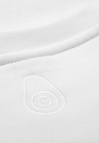 Sudadera de algodón blanca con un logotipo de aguacate bordado texturizado y patrones circulares en la parte frontal, debajo del escote.